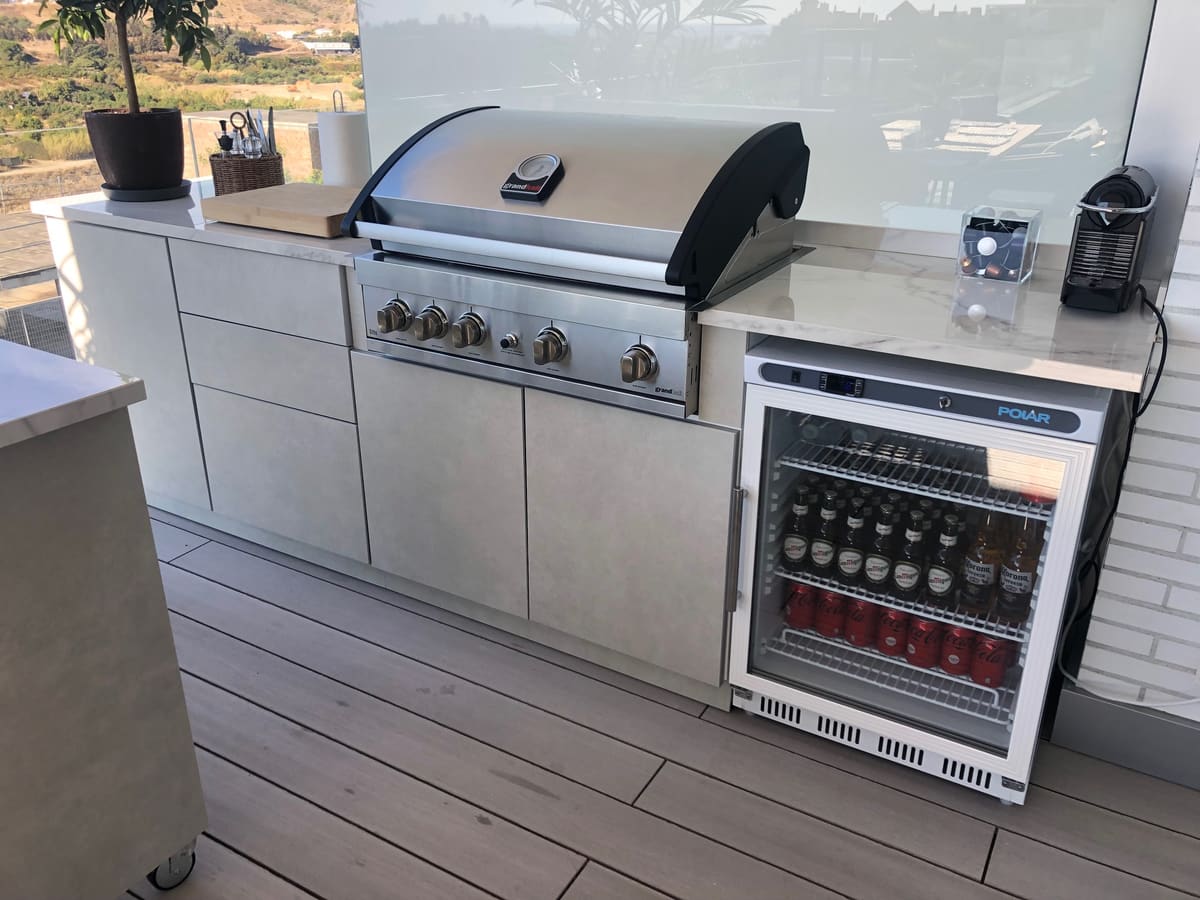 Gas BBQ and drinks fridge side by side in an outdoor kitchen