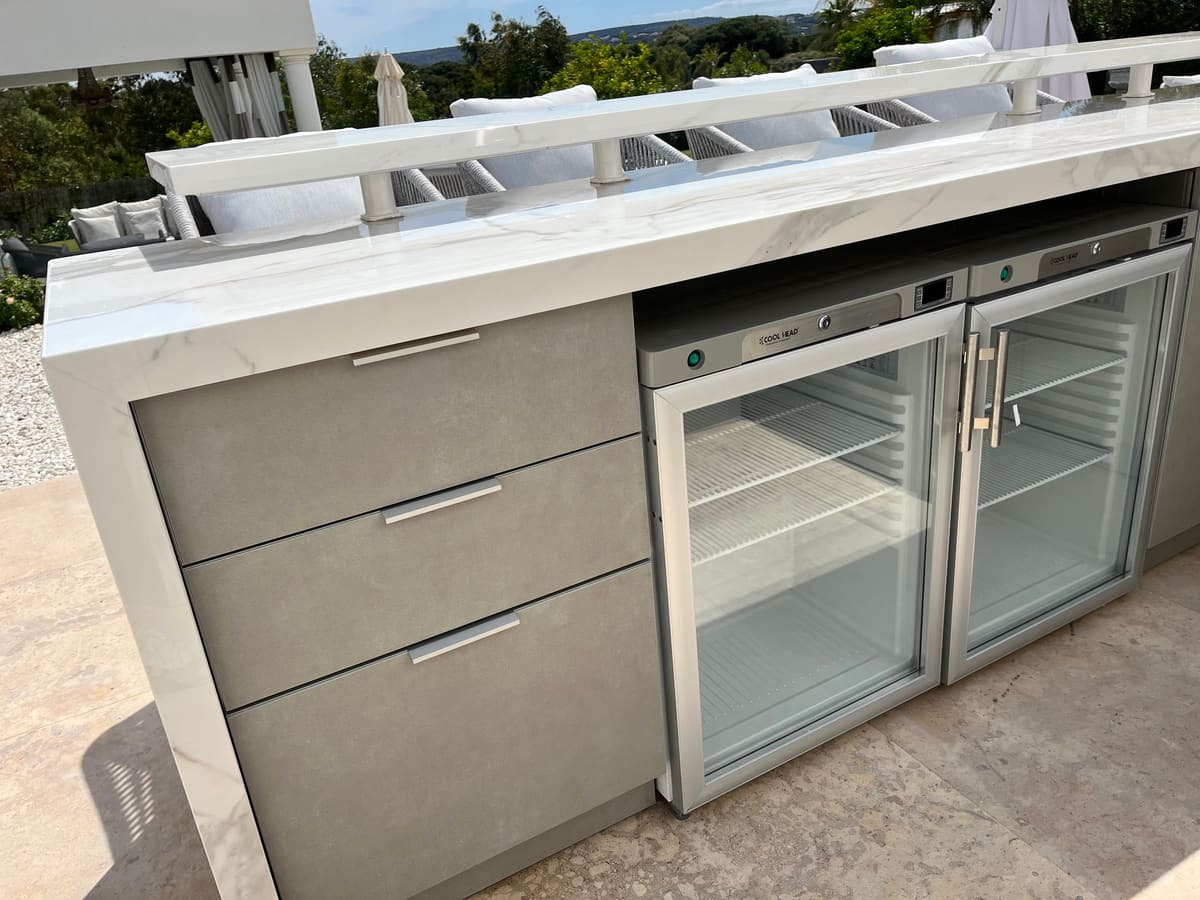 Two glass-door drinks fridges and drawers in a finished outdoor kitchen