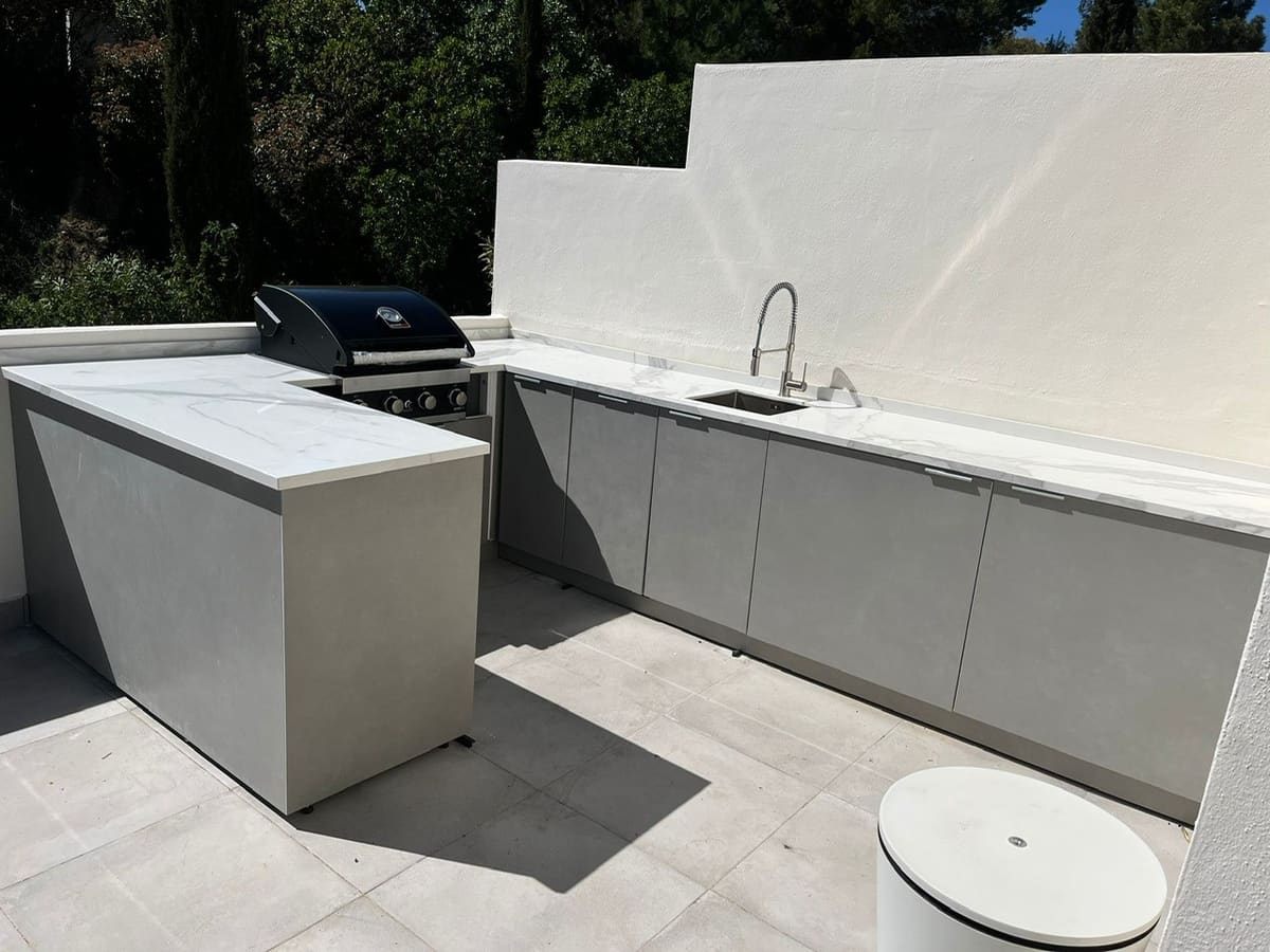 L-shaped outdoor kitchen fitted to a walled roof terrace